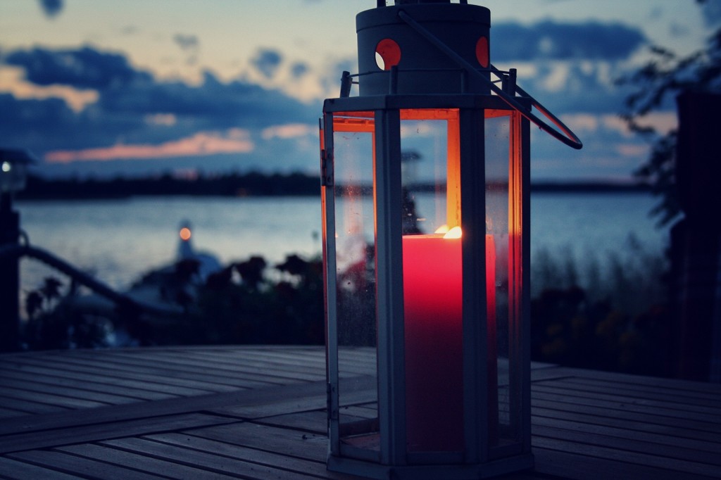 A candle in a lantern burning in the evening.