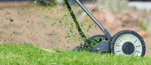 A lawn mower cutting the grass and throwing out grass clippings